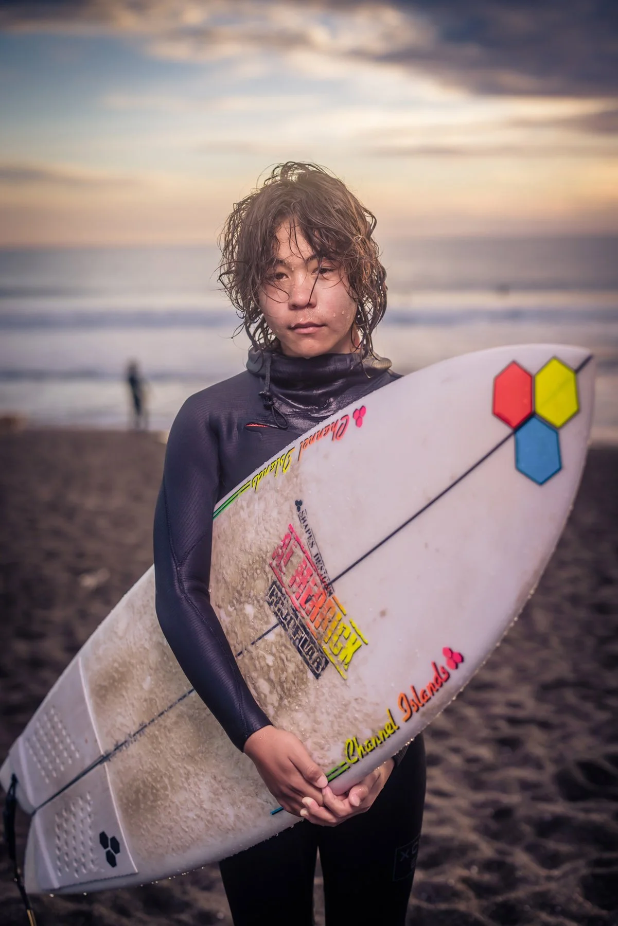 Young boy in wetsuit with surfboard
