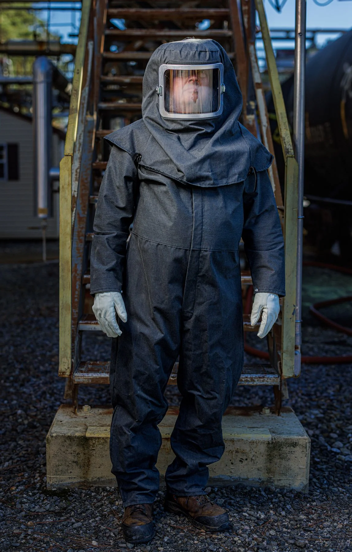 Industrial Photographer Richmond - Industrial Photographer Richmond captures a person in a full hazmat suit and gloves standing by outdoor metal stairs.