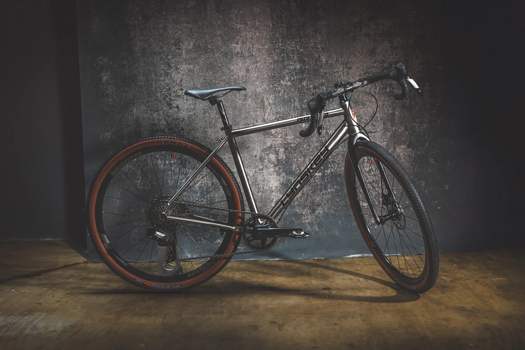 Industrial Photographer Richmond - A silver gravel bike with drop handlebars and brown tires stands indoors, captured by an industrial photographer in Richmond.