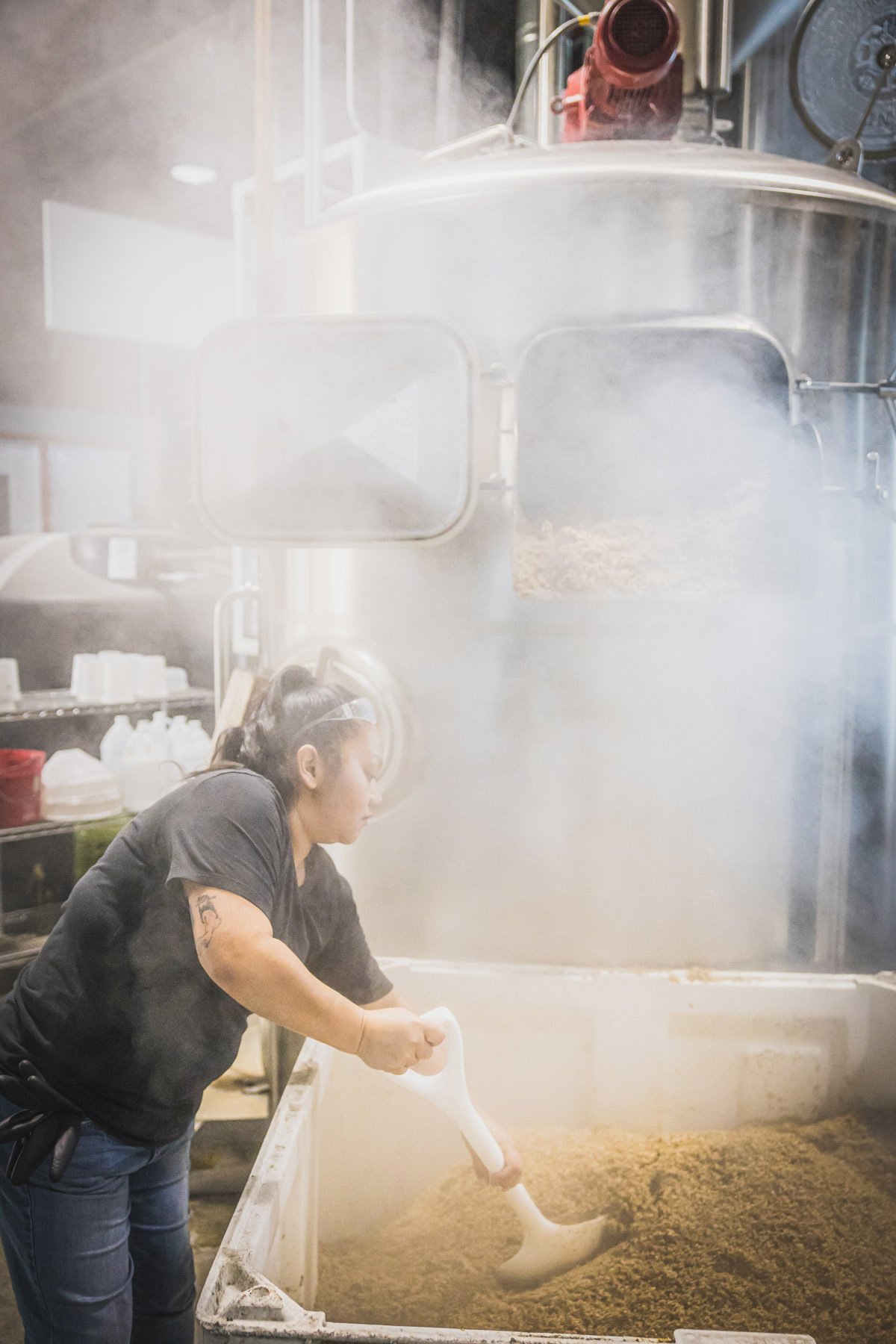 Industrial Photographer Richmond - An Industrial Photographer Richmond captures a worker shoveling grain from a steaming brewery tank into a container.