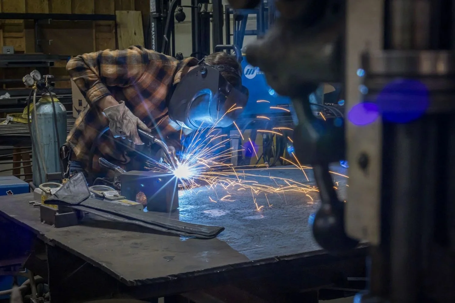 A man in welders mask welding in Shockoe Valley factory