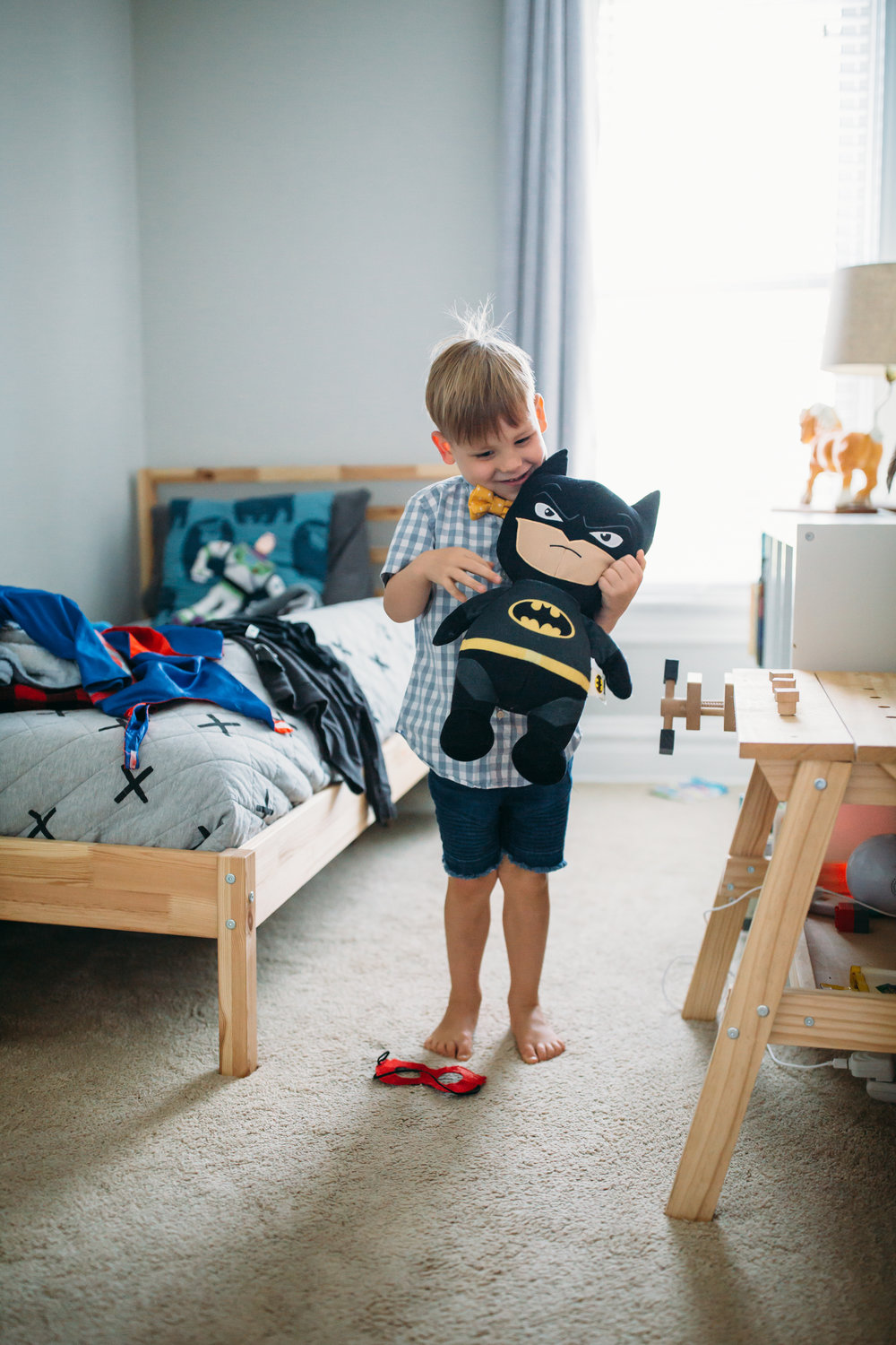 natural family photography St. Louis, at home family portraits Denver, young boy playing with batman