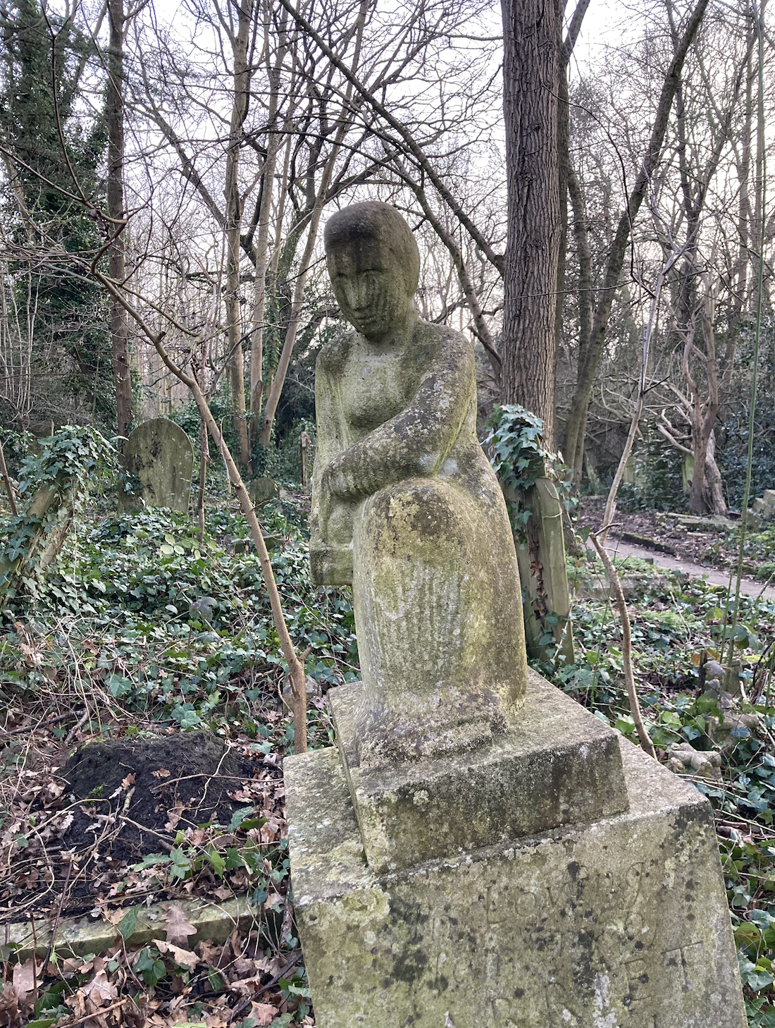 Harriet Delph's distinctive sculptural monument grave in Abney Park, set against a backdrop of trees.