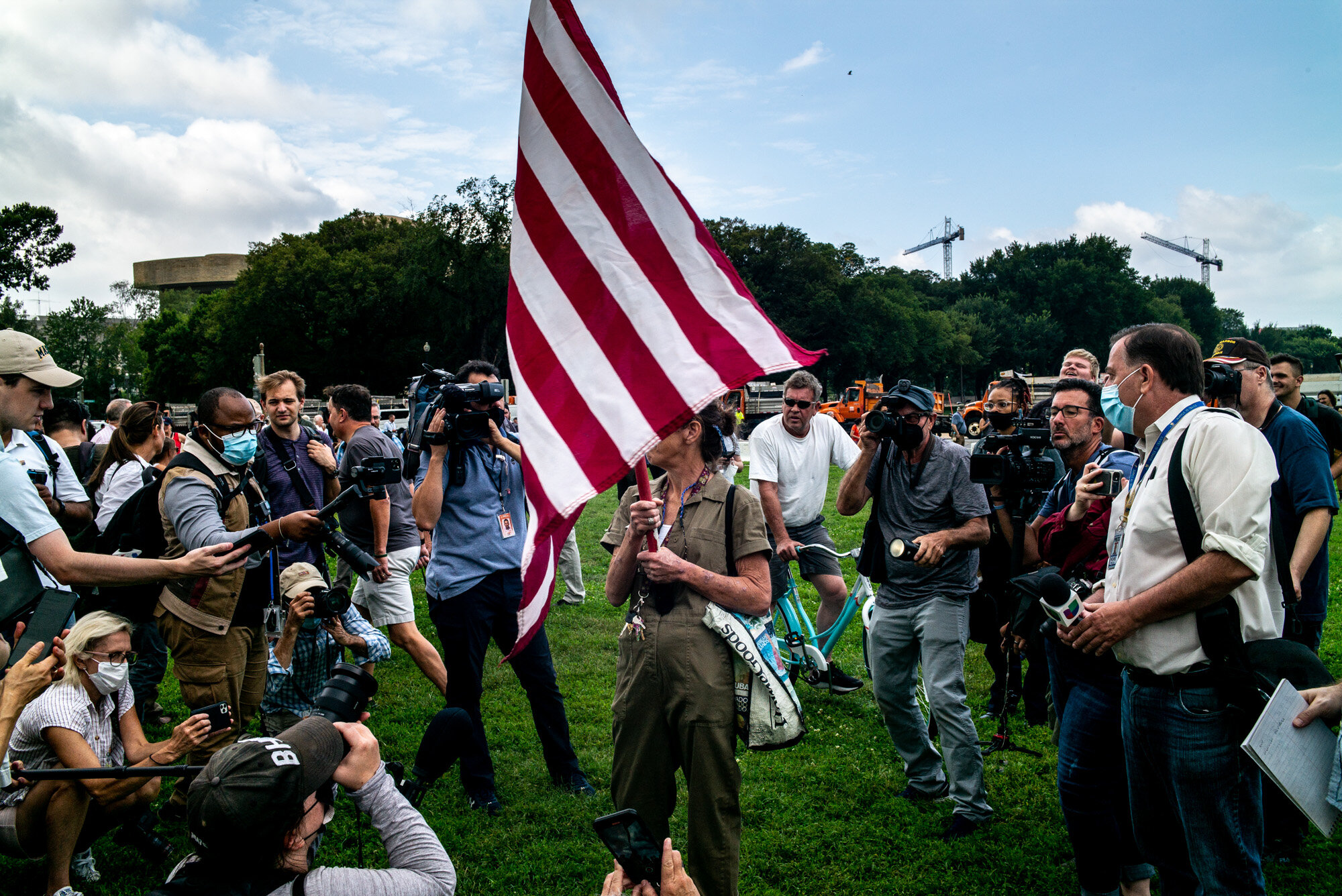  Press surround protestor with an American flag. 