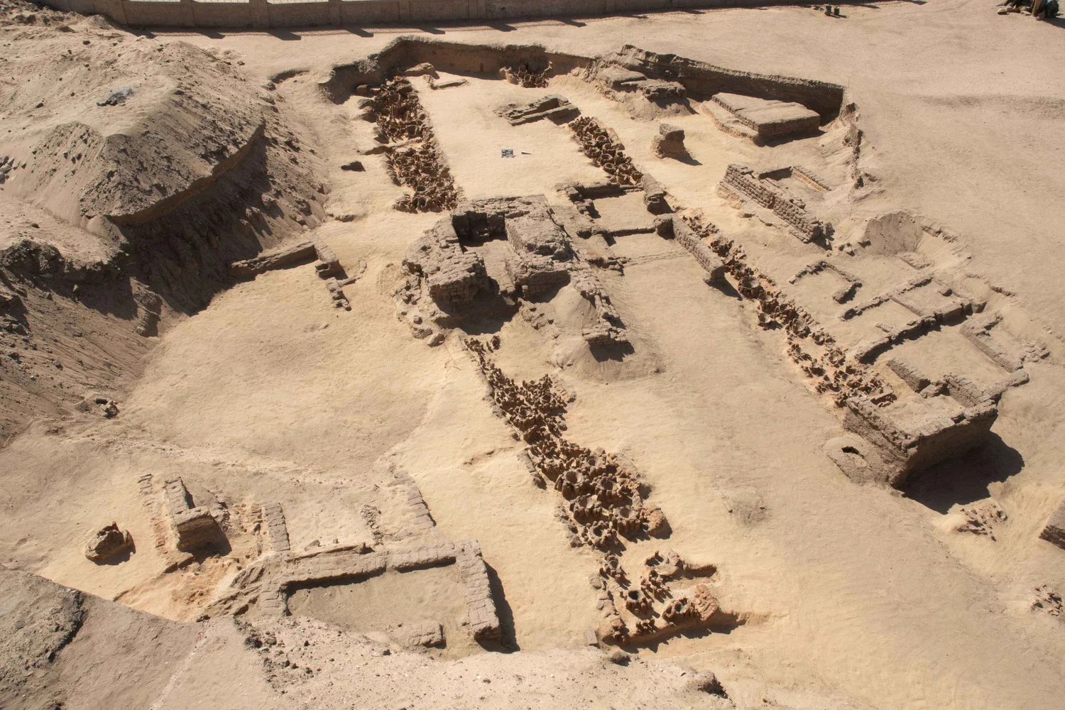 Excavated rows of ancient beer-vat emplacements at the Abydos royal brewery in Egypt