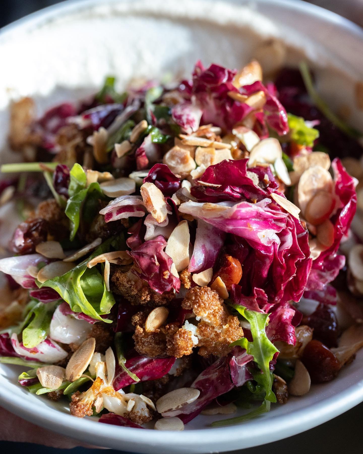 This salad is rad: warm fried cauliflower, bitter rads, pickled cherries, crunchy almonds, and a smooth silky bed of almond cream.

Cauliflower and Radicchio Salad, pickled cherries, arugula, sherry vinaigrette, almonds, almond pur&eacute;e. 

At a G