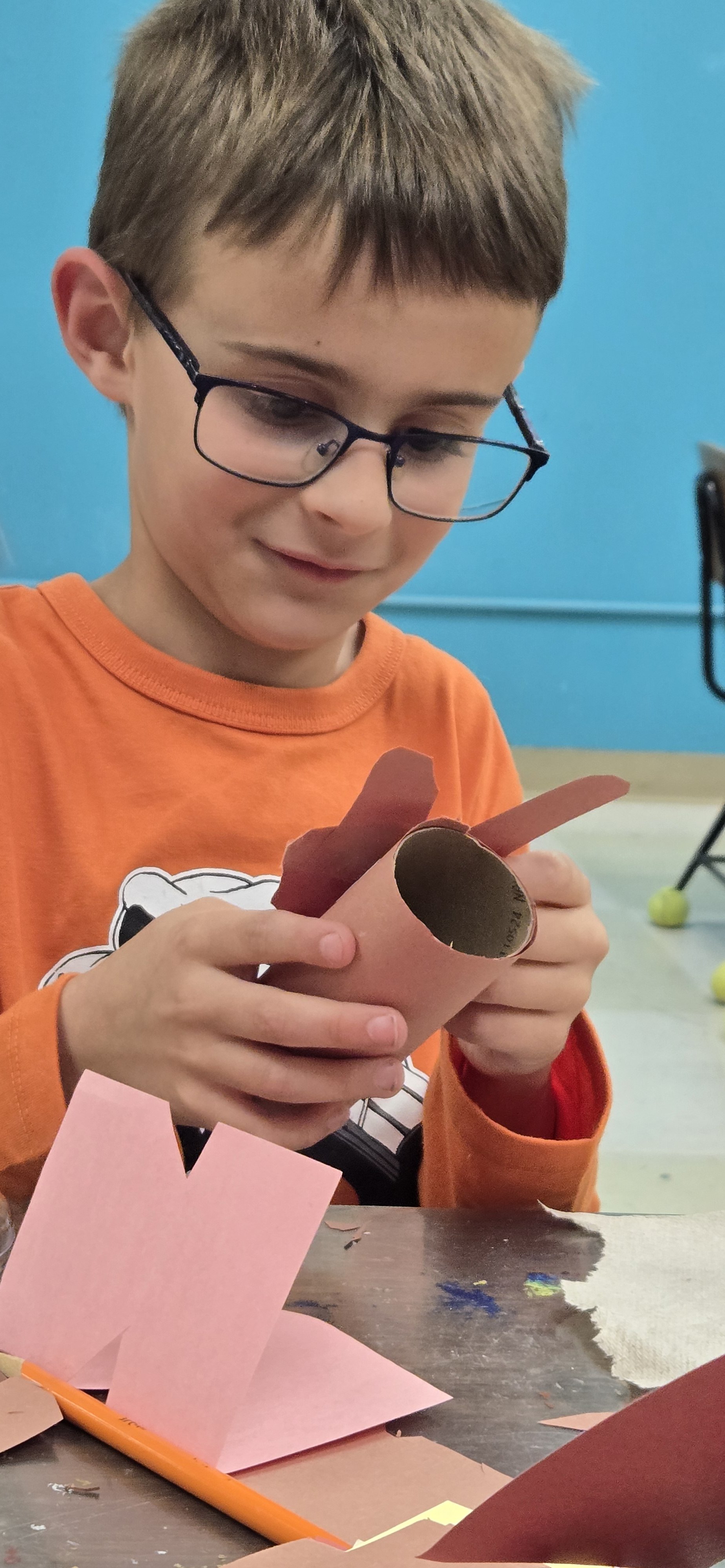 A child creates a sculpture out of cardboard and construction paper