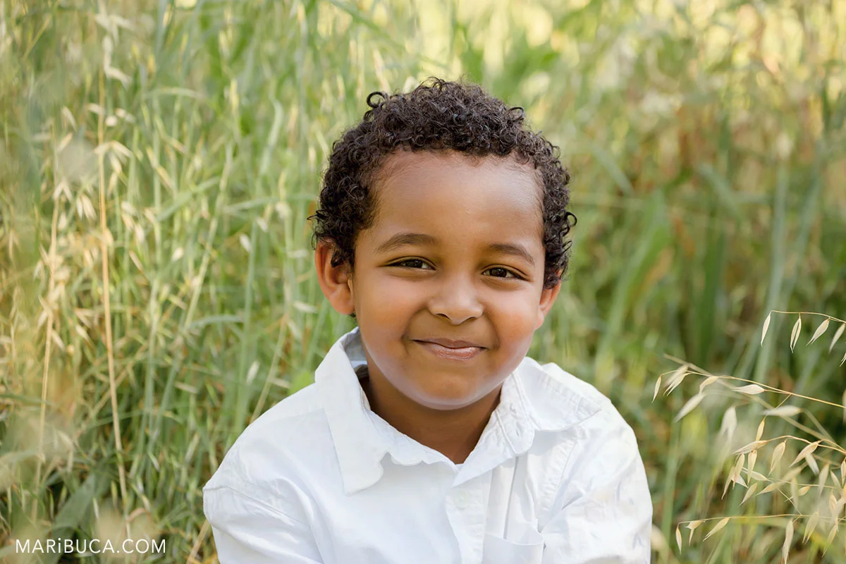 the boy smiling portrait in the green grass