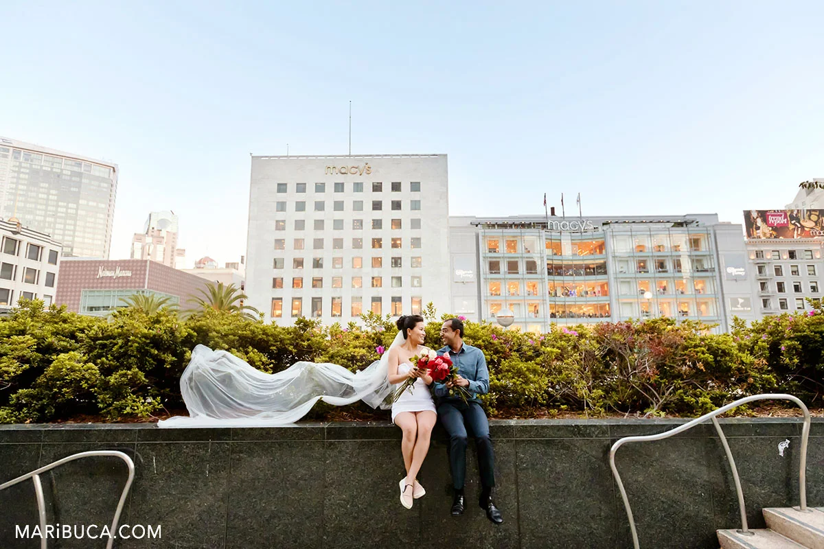 gorgeous bride and handsome groom look each other and in the background Macy's