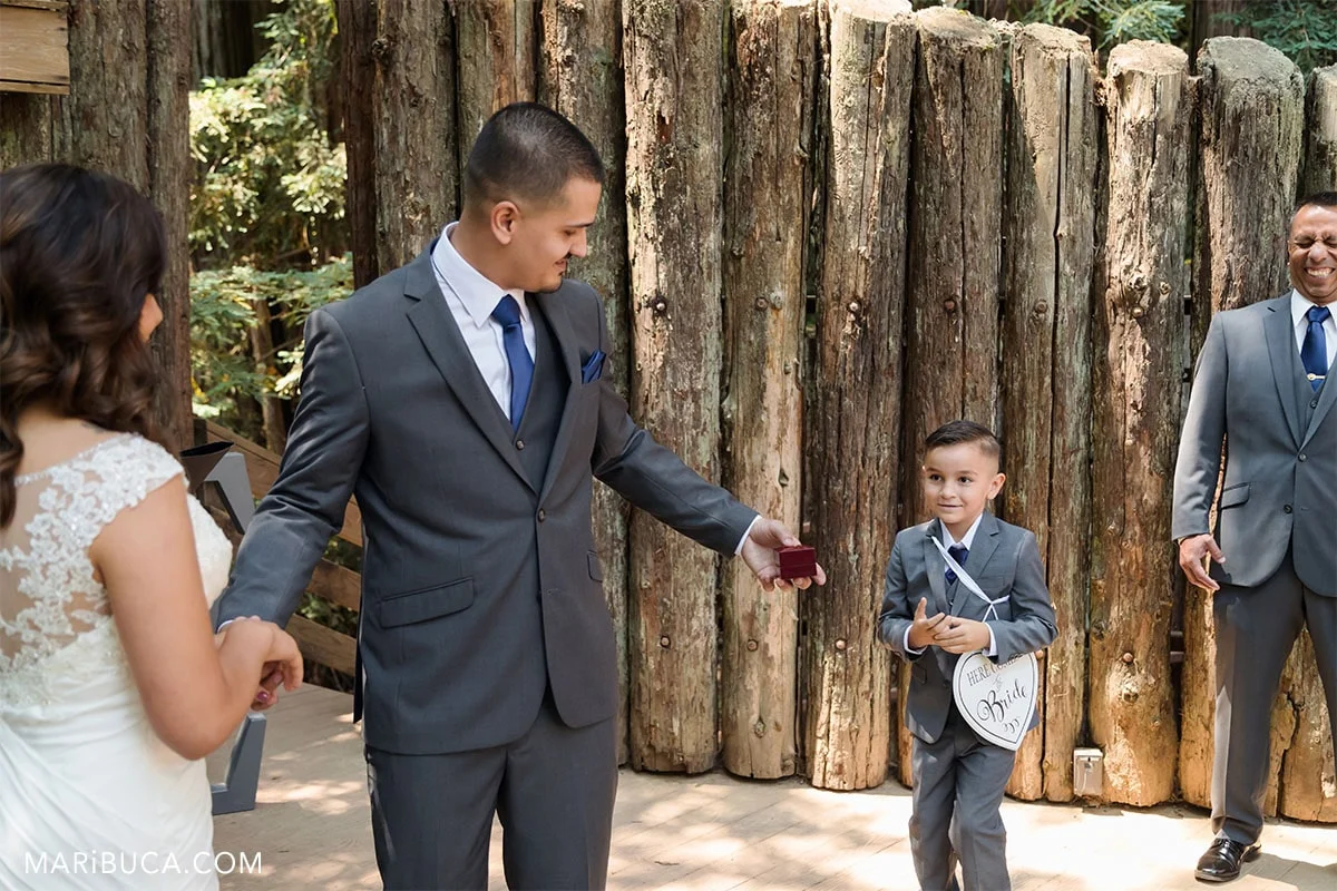 Bride and groom as the parents look in their son who is ring bear.