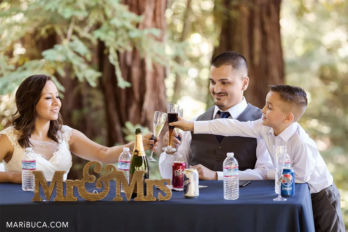 cheers in the wedding bride, groom and son in the county park.