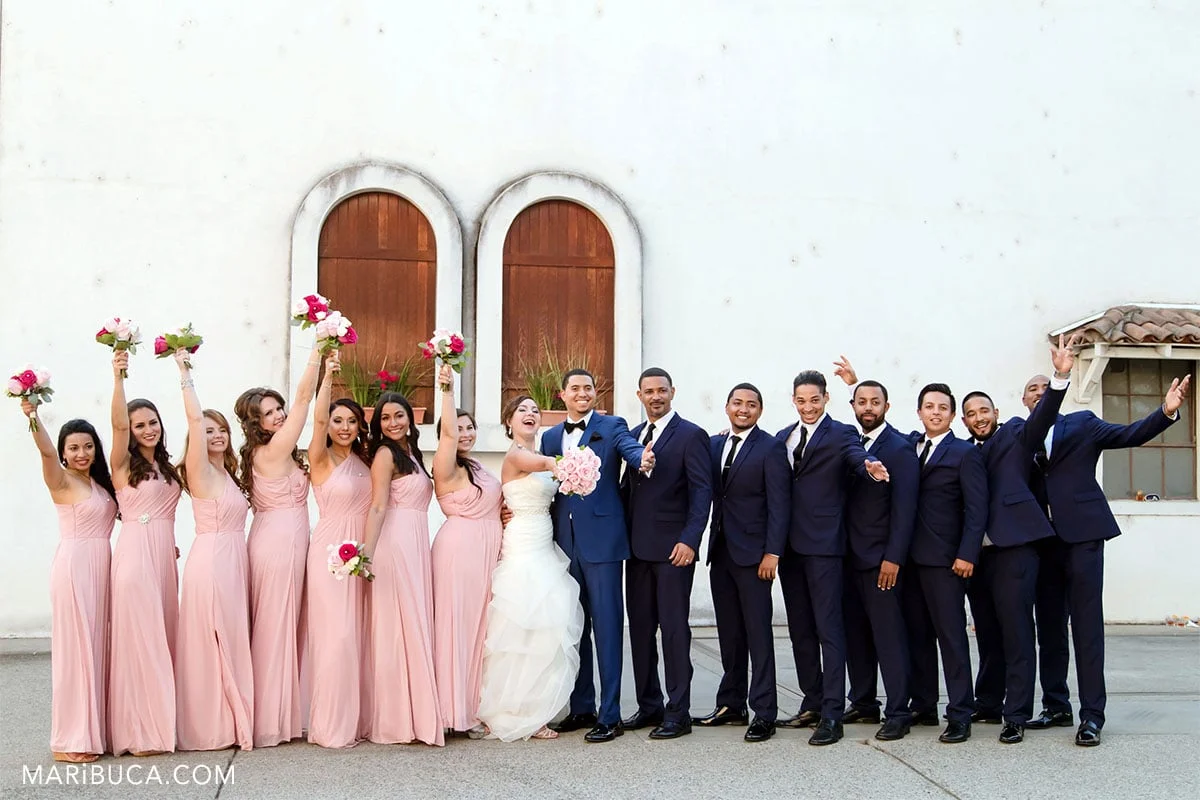 bridesmaids, groomsmen and newlyweds ready to take pictures. Funny faces.