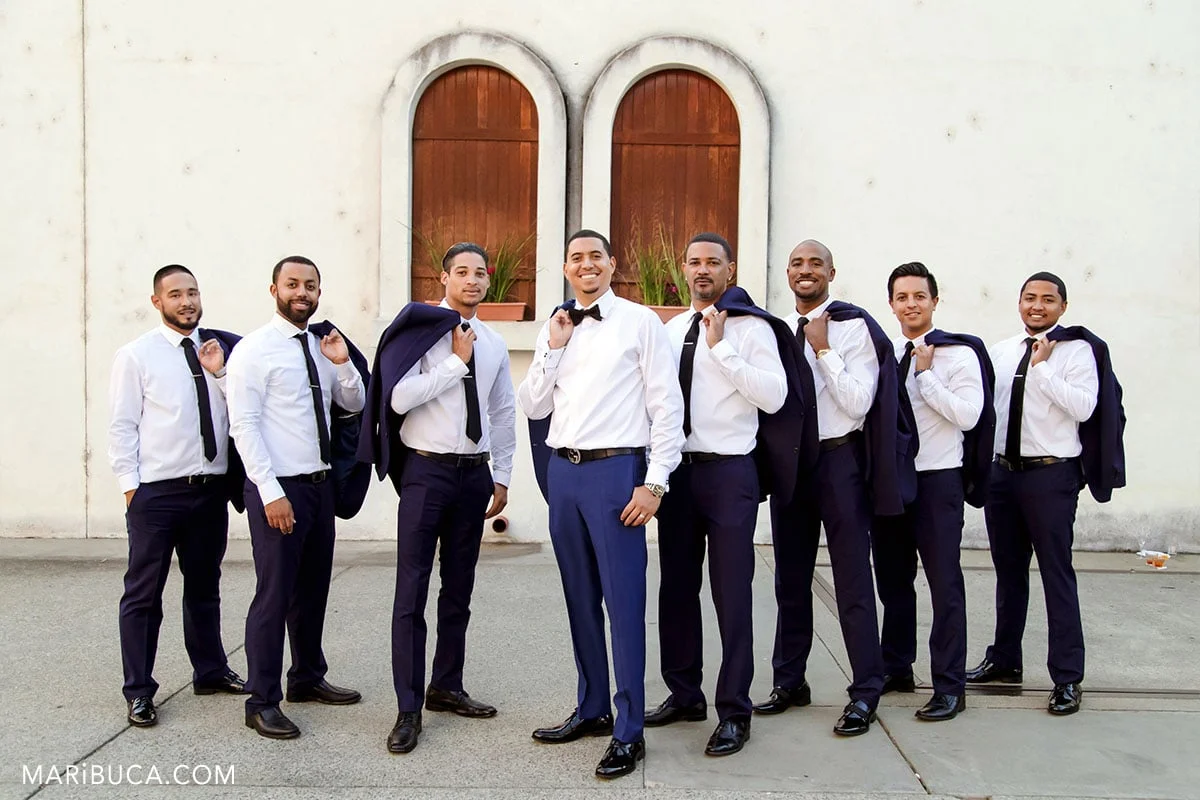 The groom and groomsmen have fun for taking pictures.