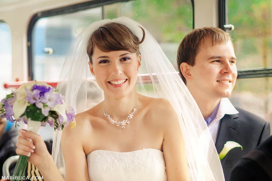 bride and groom smile and ride the tram to their wedding