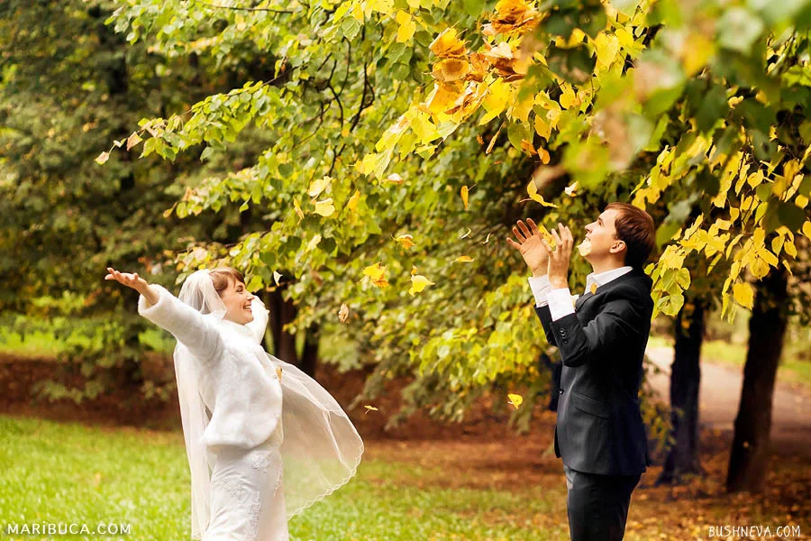 bride and groom throw up foliage in the park in Indian summer in the Golden Gate Park.