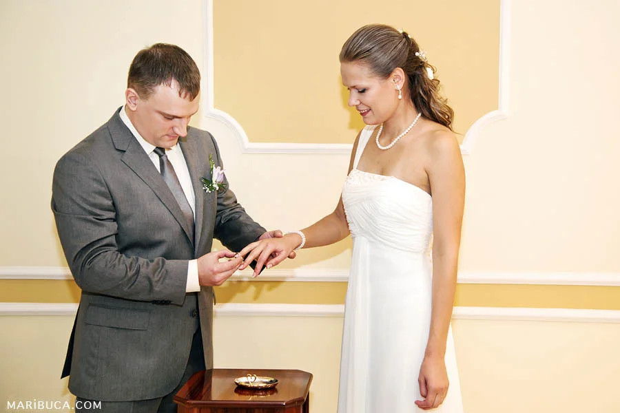 Groom put the wedding ring on the bride’s finger in the wedding ceremony