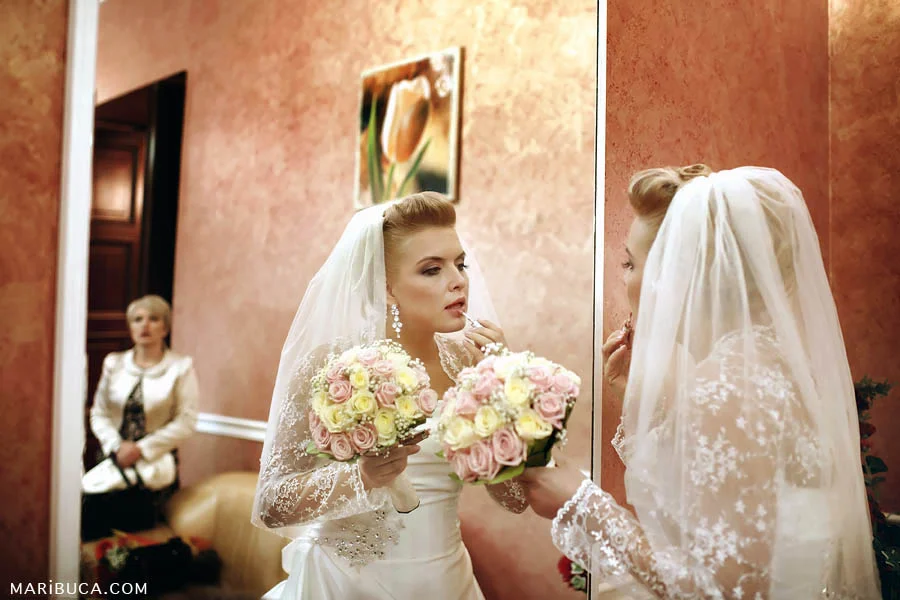 The bride doing her last make up touch before the wedding ceremony.