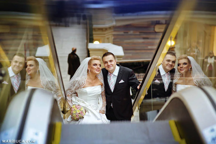 Triple images of the bride and groom in reflections from the glass of the escalator in the Fairfield, San Jose.
