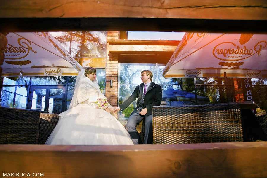 Groom holding hands and looking at each other against the blue illuminated building