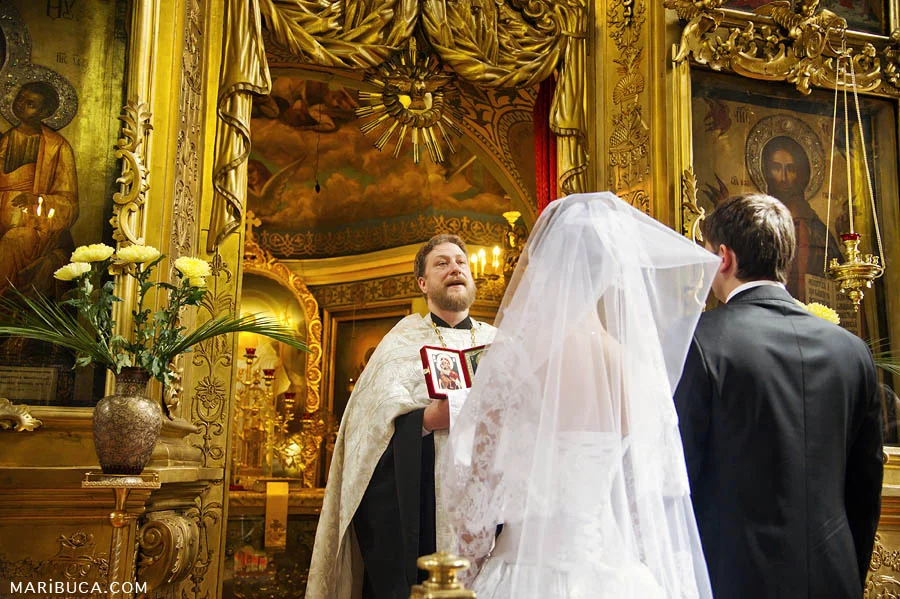 the priest congratulates the newlyweds that they became a husband and wife in the church.