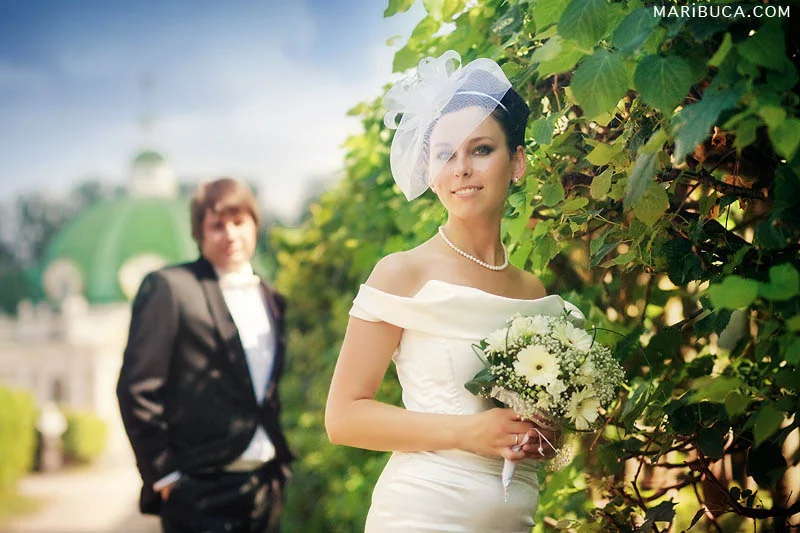 The bride and groom are posing in the beautiful park in the Hayward garden.
