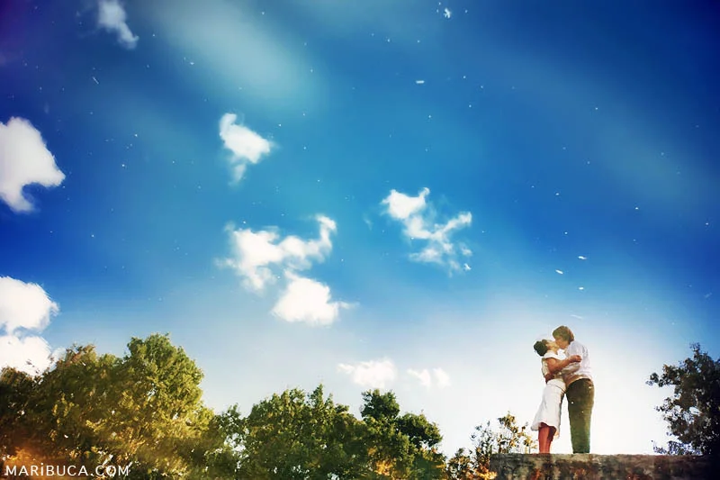 Reflection of the water with clear view of the bride and groom are kissing each other and blue skies