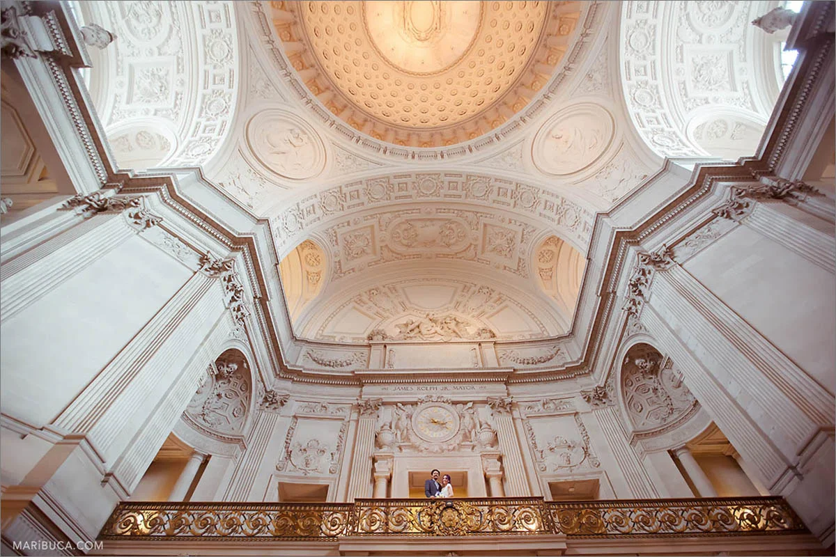 The beautiful architecture of the San Francisco City Hall inside and newlyweds couple.