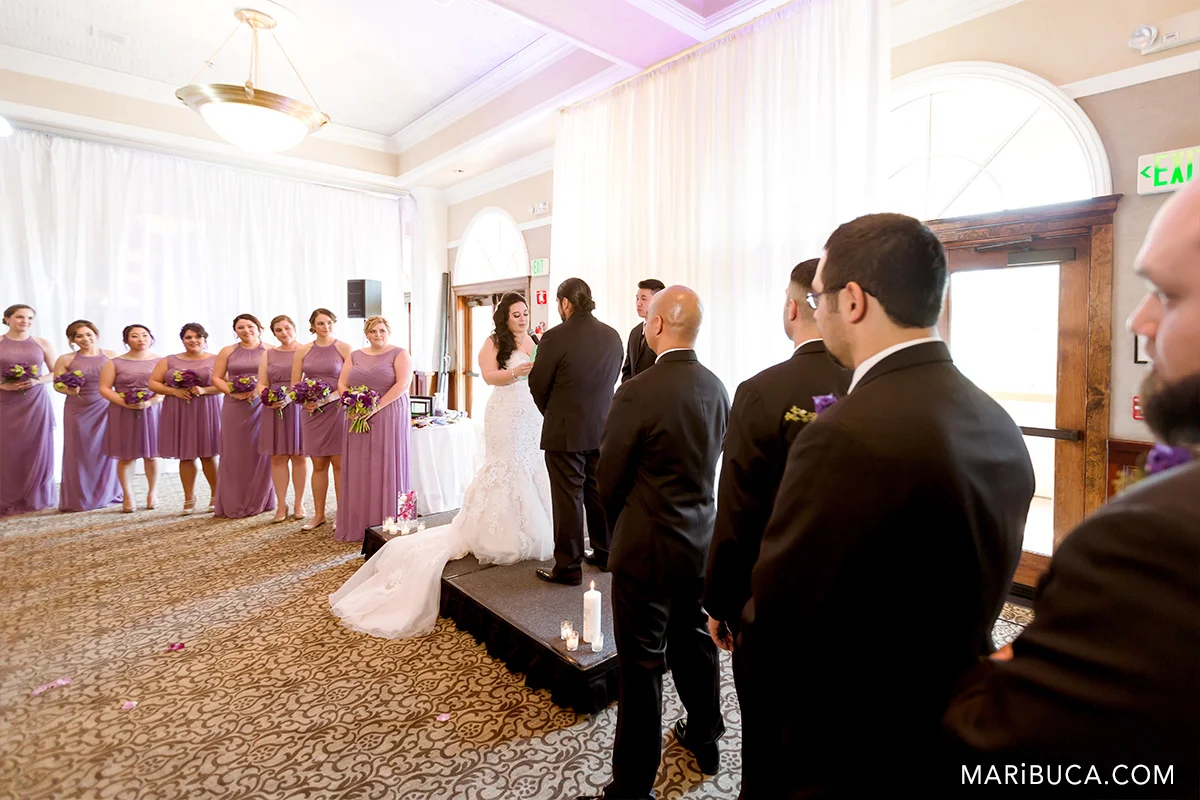 Bridal party and wedding couple during ceremony in the Traditional during wedding ceremony in the Villa Ragusa Campbell