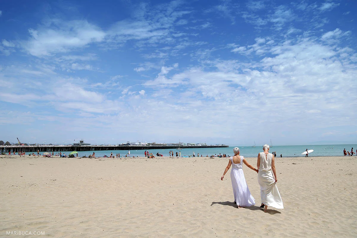 Brides walking in the Cowell beach after their wedding ceremony in the Santa Cruz