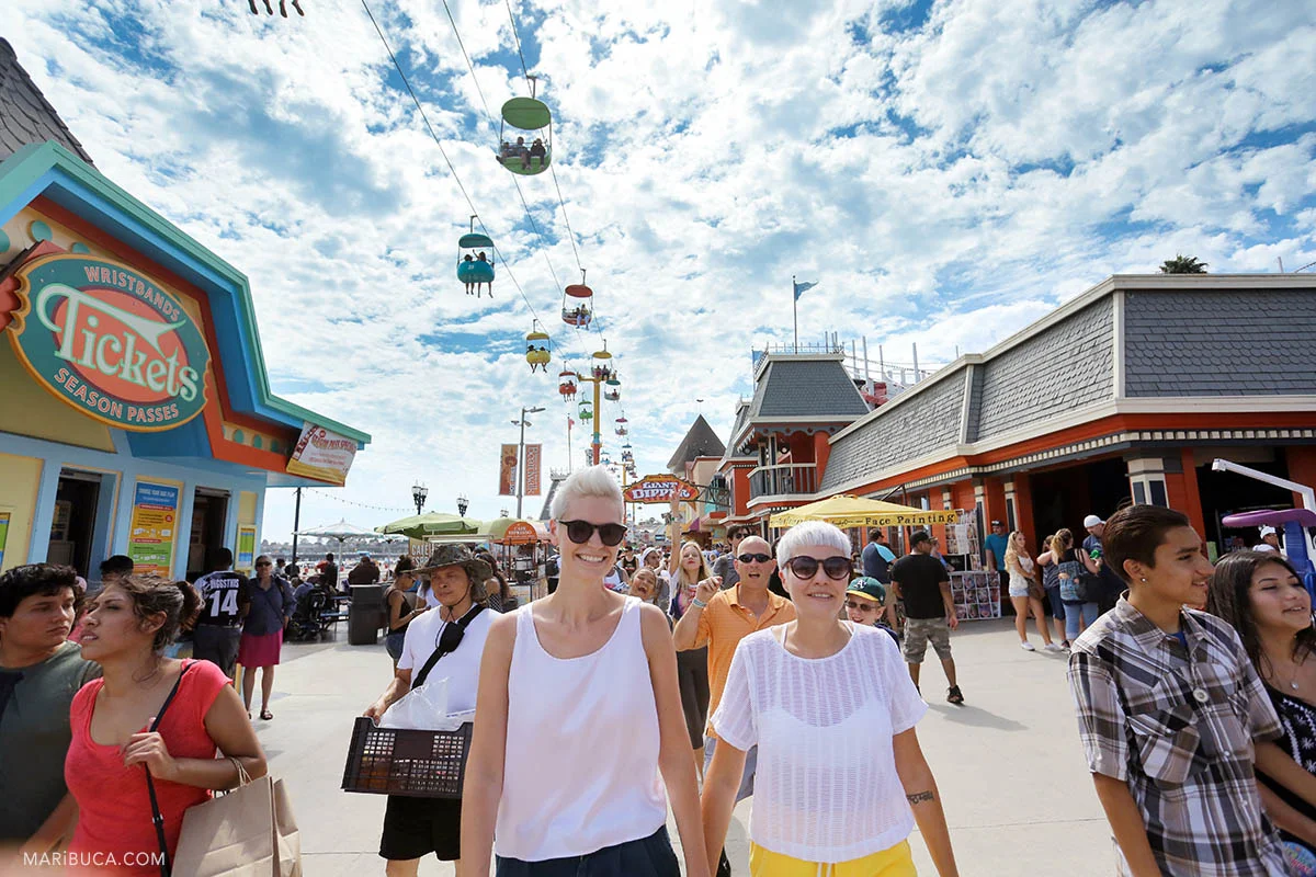 Adorable newlyweds girl are walking in the Boardwalk, Santa Cruz&