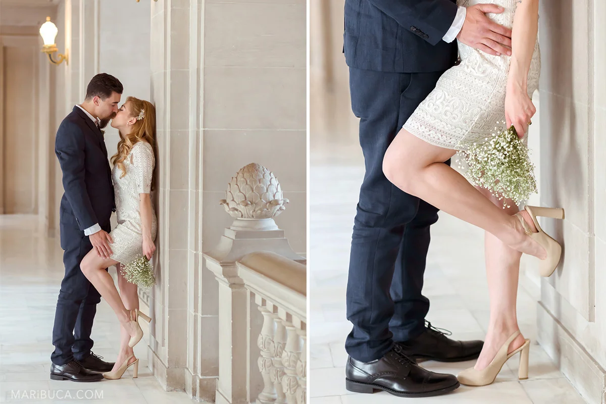 the groom leaned the bride against a pole and gently is touching her leg and they are kiss each other in SF City Hall. Wedding element: groom’s dark blue pants of the groom who touches the waist of the bride leaning against the wall and leaning one leg against the pole.