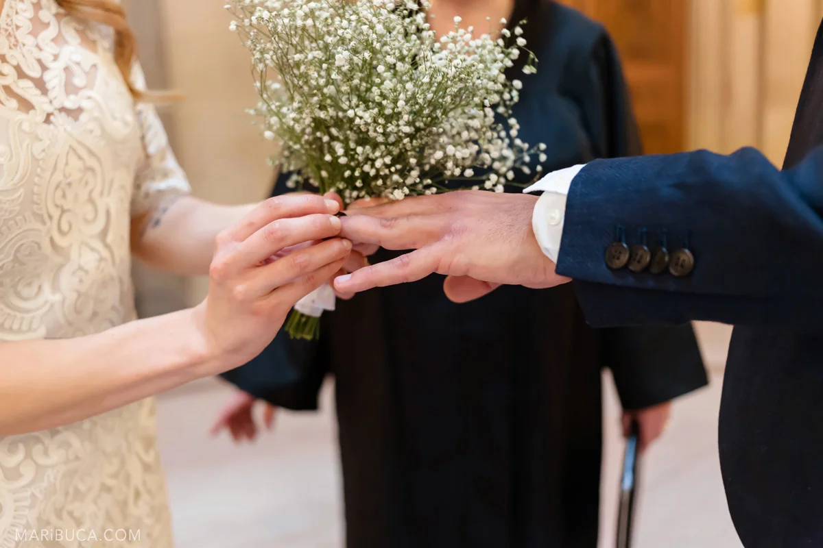 Hands when couple exchange wedding rings. The bride put on the wedding ring in the finger in the wedding ceremony SF City Hall.