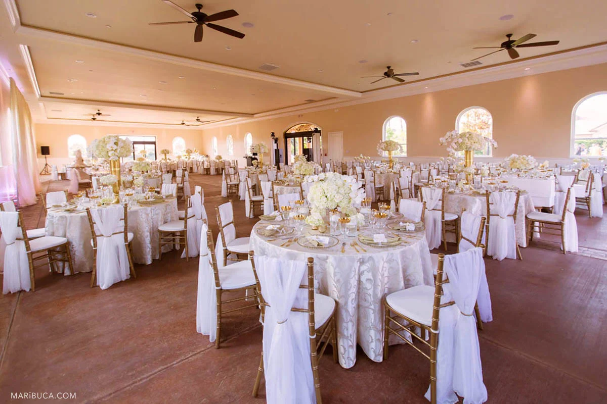 Wedding reception detail: rounded white tables, white flowers. Indoor in the Newberry Estate Vineyards