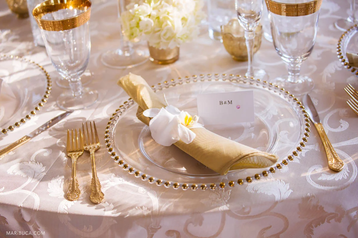 Wedding details during reception in the table: whitecloth, nice cards, golden silvers, wine glasses
