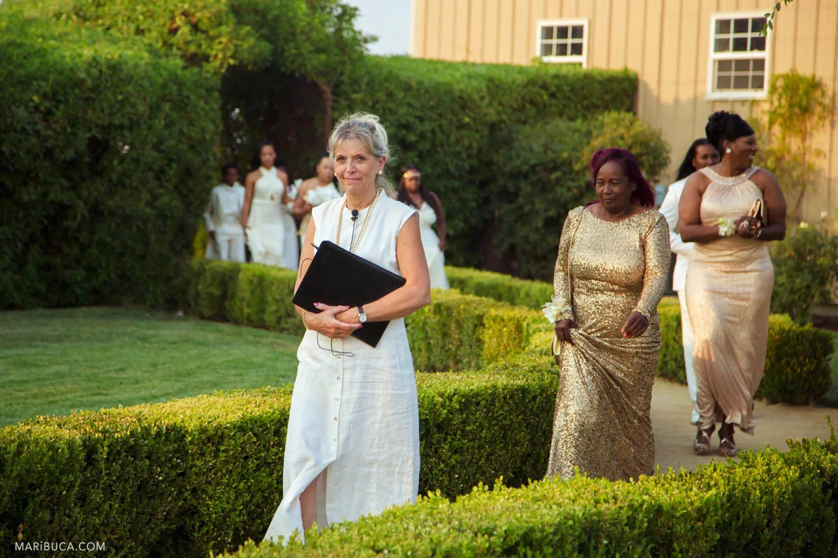 Reception is starting and officiant, bridesmaids are going down the aisle in the Newberry Estate Vineyards.