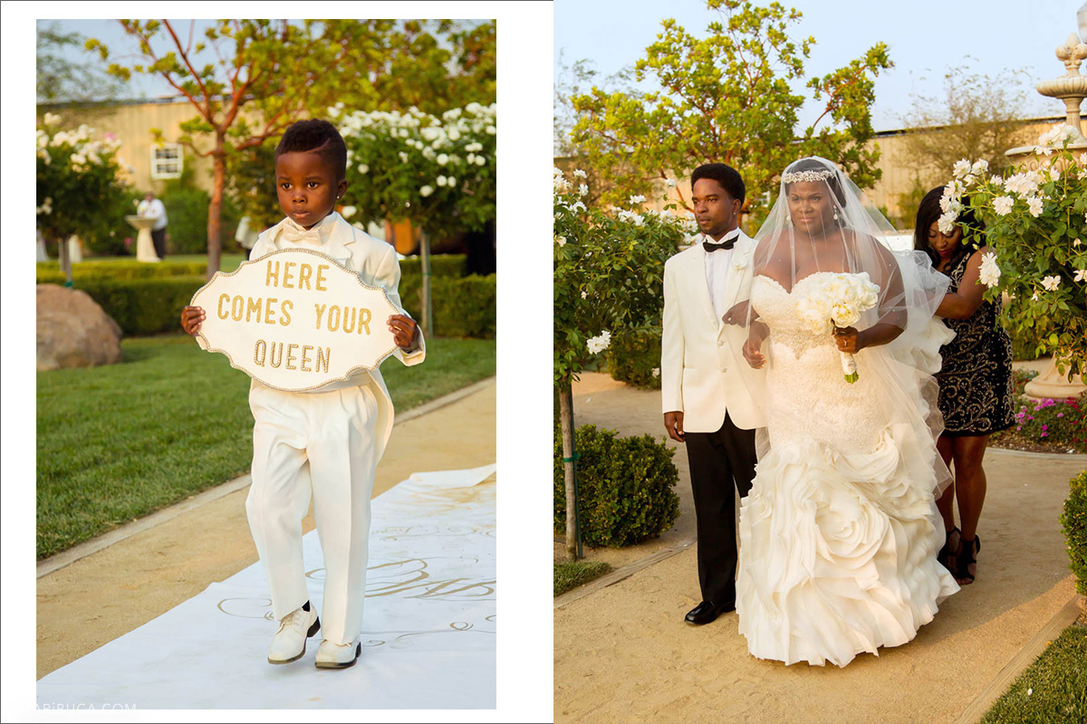 Barrier Rings in the white suit walks with sign “Here Comes Your Queen”. The bride walks with brother go down the aisle.