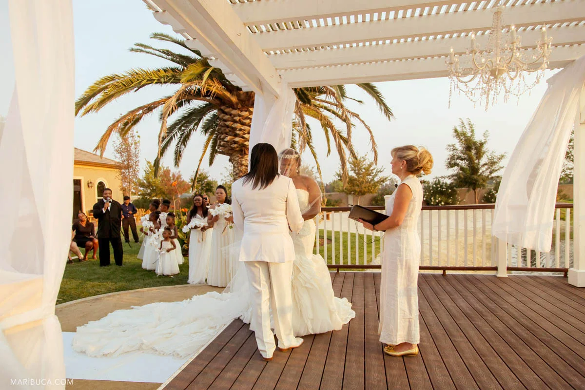 Adorable bride and groom, and white wedding theme around during the wedding ceremony in the Newberry Estate Vineyards.