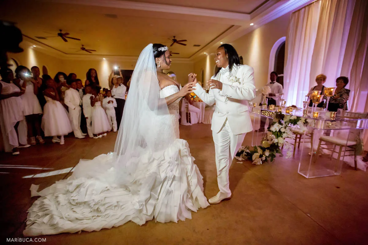 The groom and the bride with white clothes have first dance as married couple. Wedding Photographer Brentwood in the Same Sex wedding..