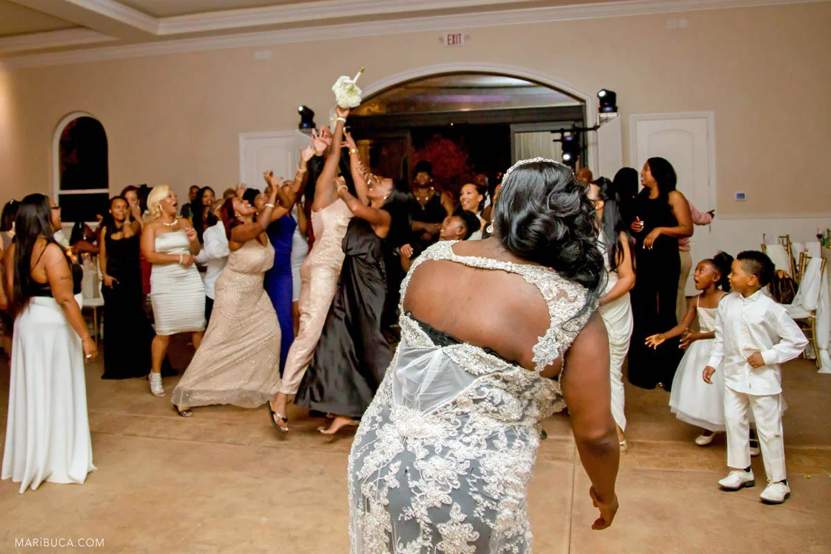 Girls try to catch wedding bouquet in the same sex wedding.