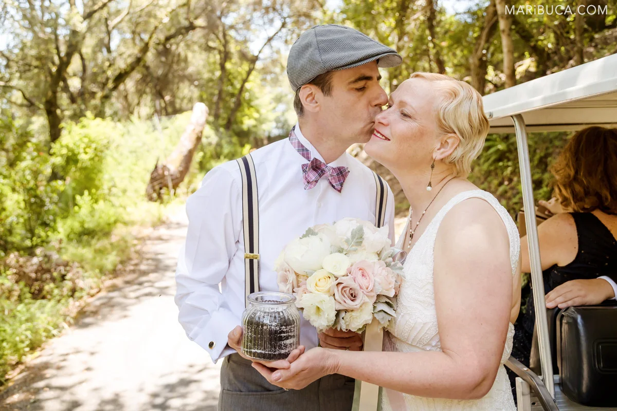 the groom kiss her lovely bride in the cheek outdoor wedding in the Los Gatos