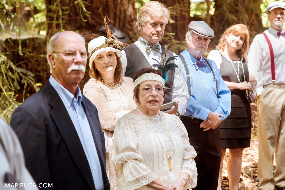 Guests in the wedding ceremony are listening the officiant. 1920s theme