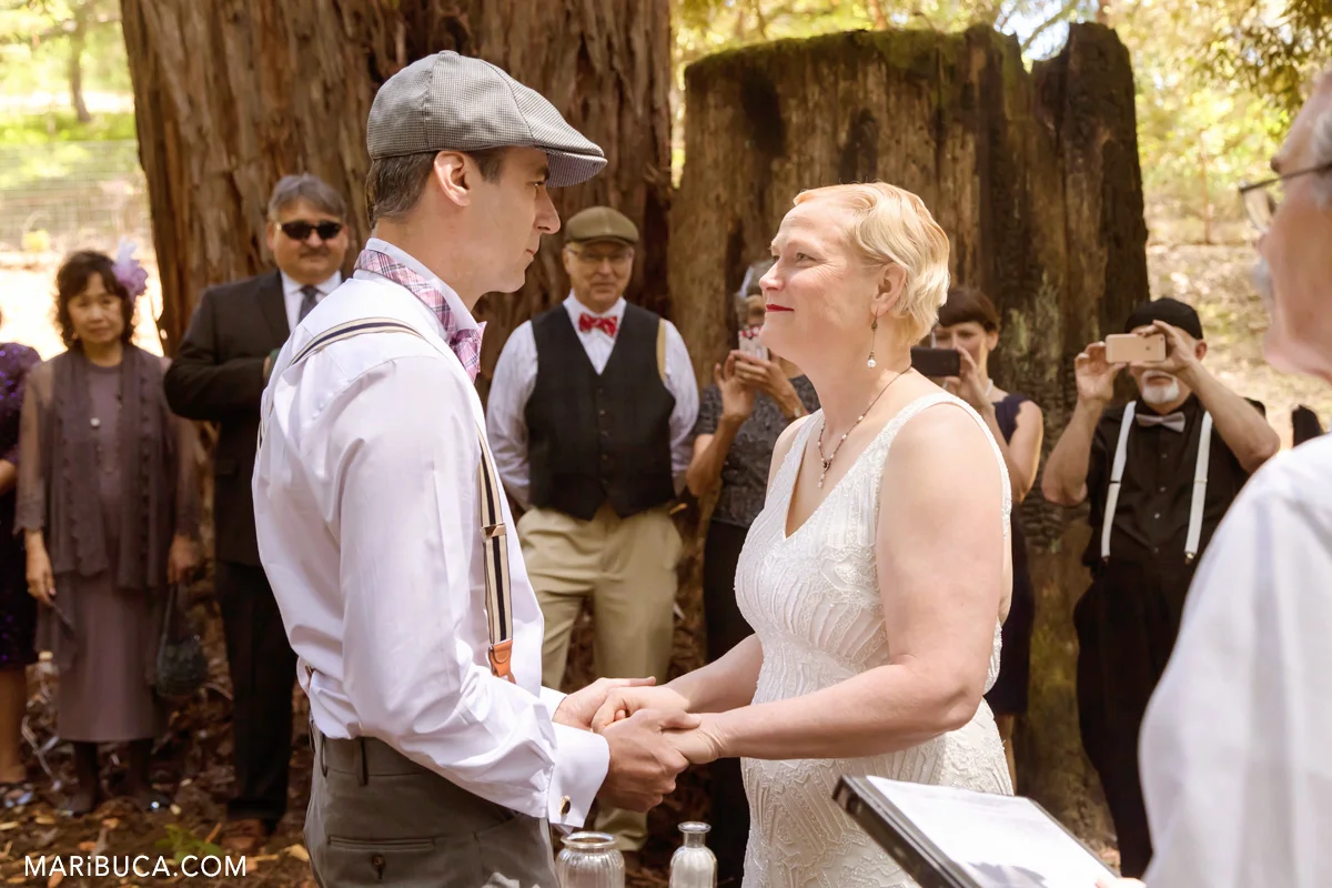 The bride and the groom are looking each other during the wedding vows.