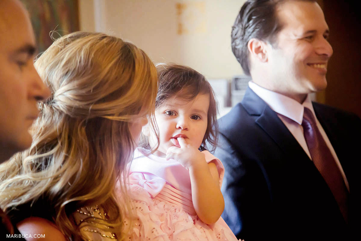 Adorable baby girl with family inside the church. The girl looks in the camera.