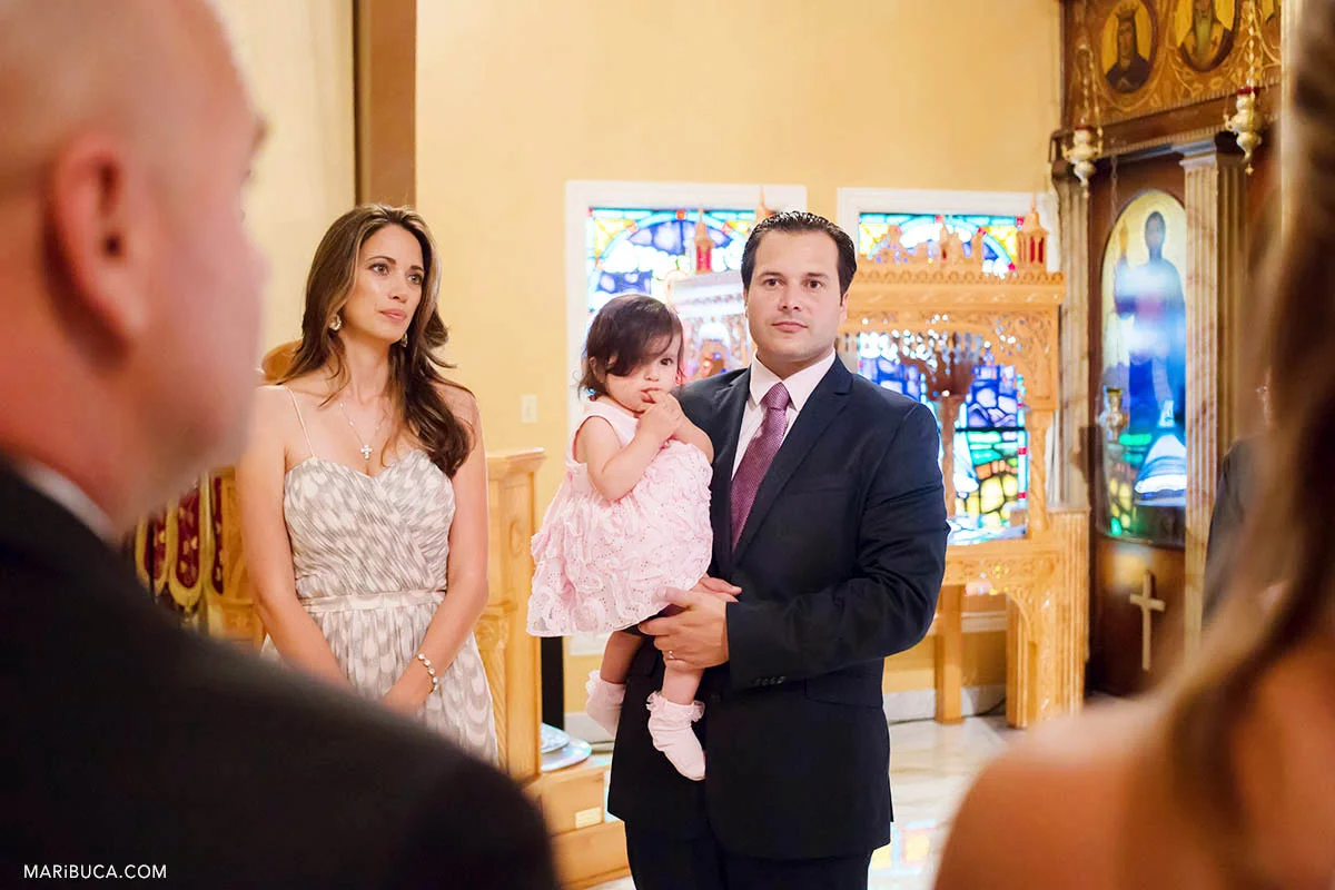 Adorable two years baby girl with family and guests during christening baptism in the San Jose Greek Orthodox Christening in St Nicholas church