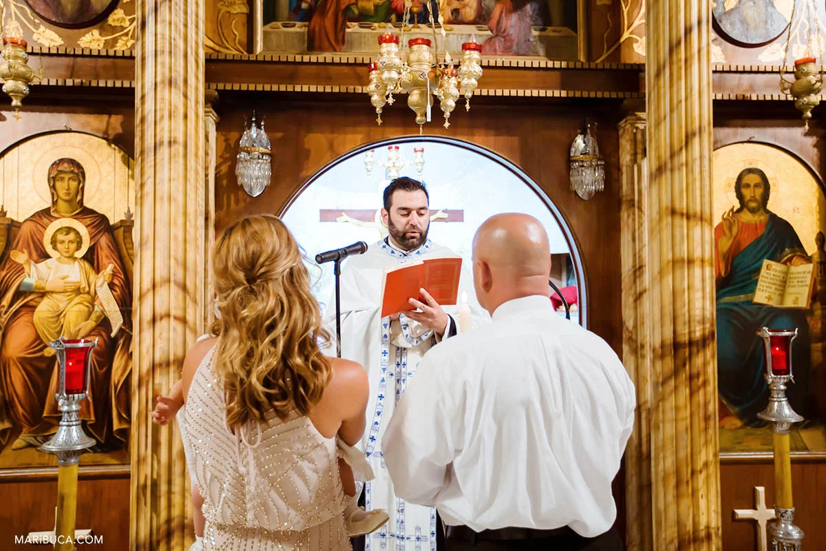 The priest read the part from the bible for godmother and godfather during Greek Orthodox Baptism.