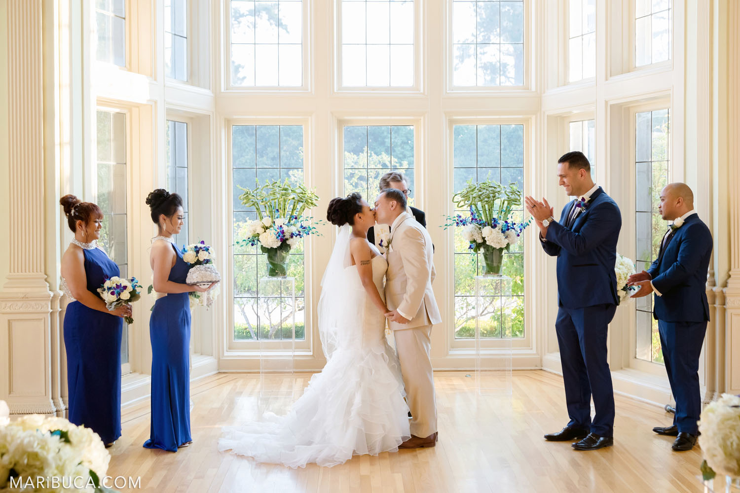 First kiss as newlyweds couple and wedding party excited and happy for them in the Dining room, Kohl Mansion Wedding, Burlingame.