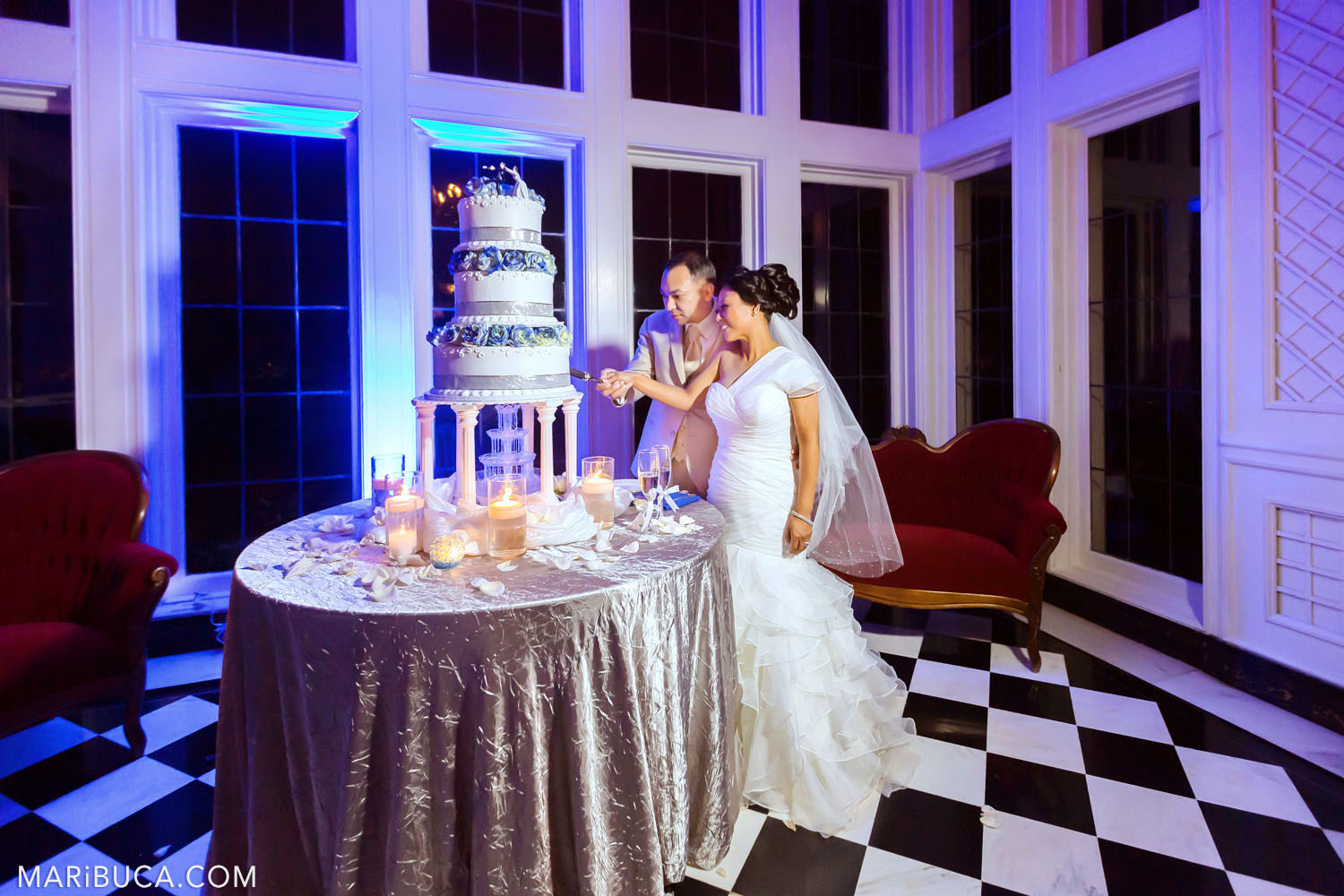 the bride and groom cut the first cake surrounded by a violet blue light in the Morning Room, Kohl Mansion, Burlingame