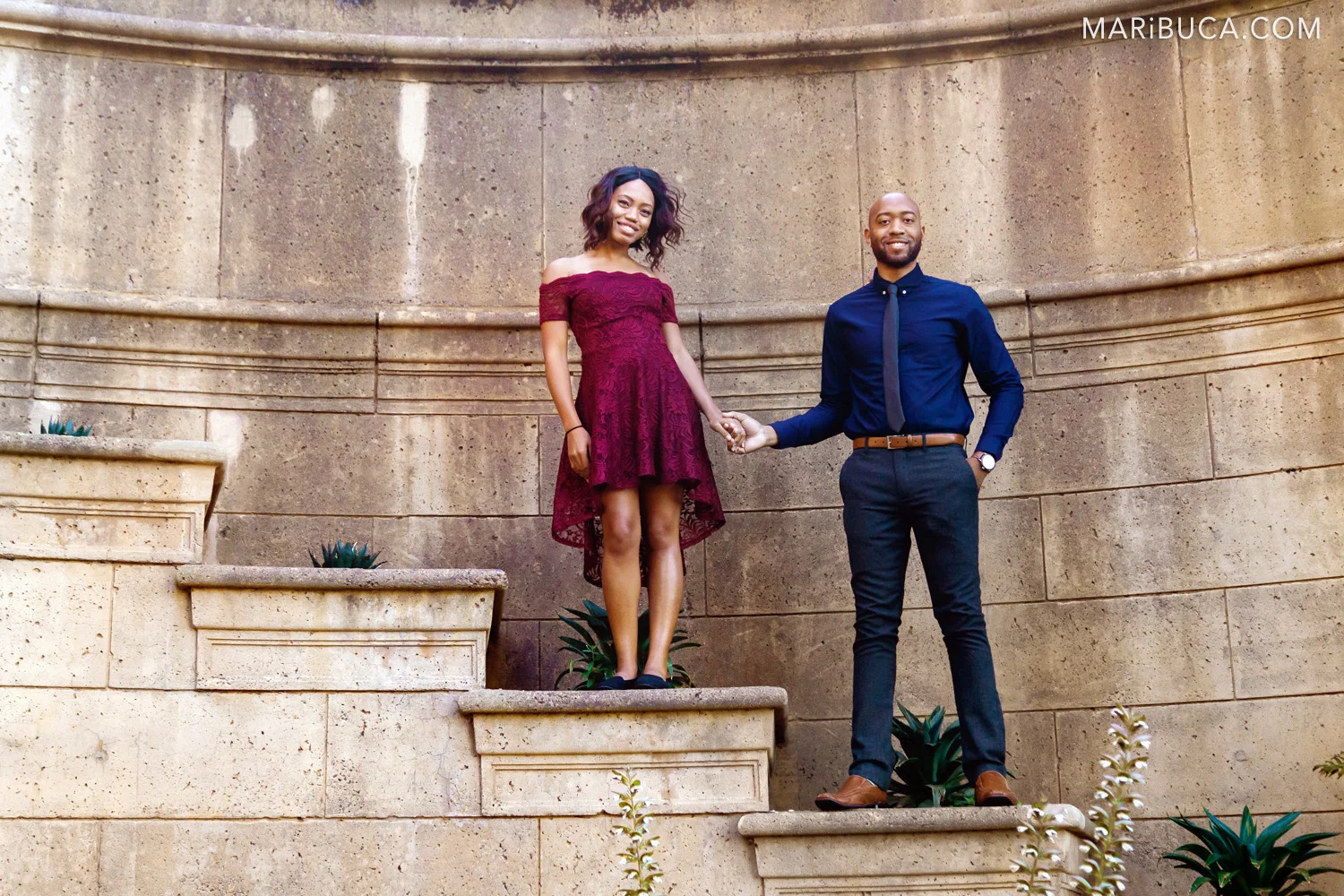 Fiance and fiancee hold hands each other and stans in the stairs in the San Francisco Palace of Fine Art