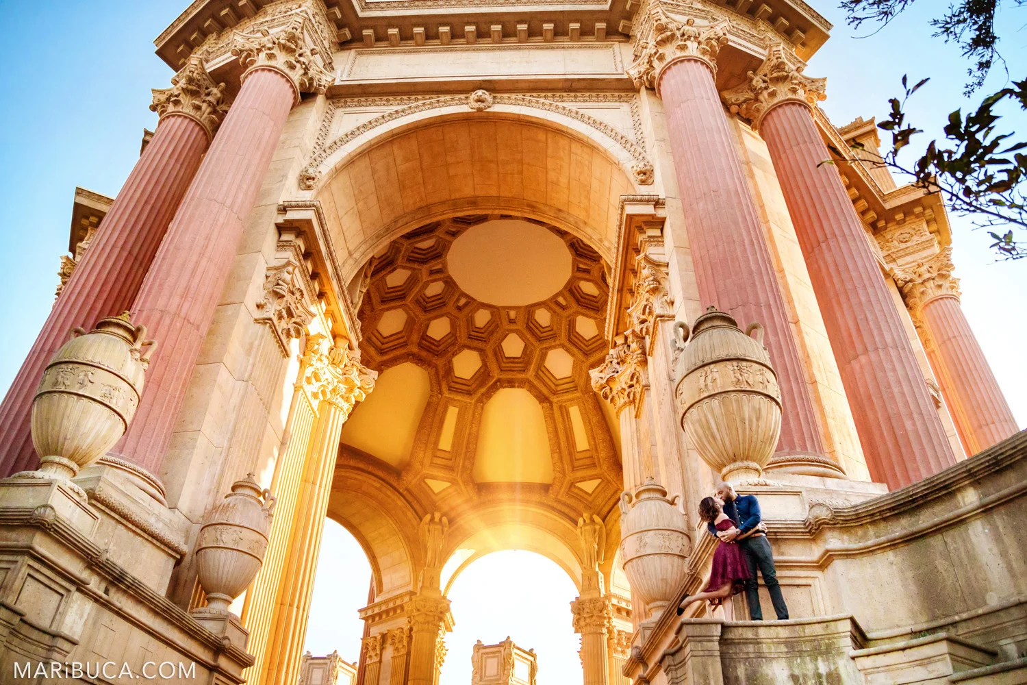 San Francisco Engagement Palace of Fine Art with fabulous couple are standing in the historical architecture stairs during orange sunset.