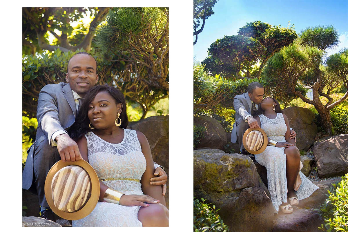 The bride and groom are sitting and kissing each other in the Hayward Japanese Garden Park.